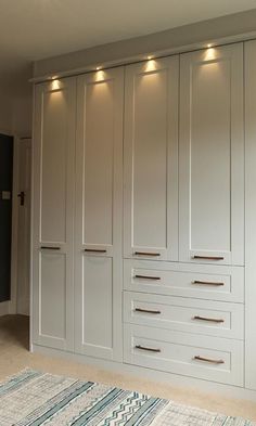 a large white closet with many drawers and lights