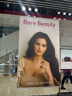 a woman walking past a large poster in a store