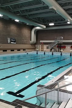 an indoor swimming pool with stairs leading up to the water's edge and tiled floor