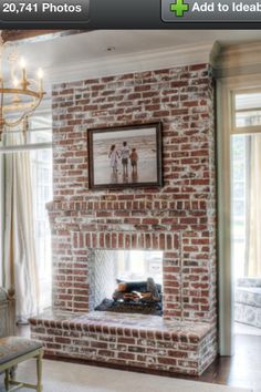 a bedroom with a brick fireplace and chandelier