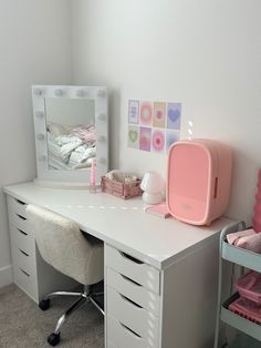 a white desk topped with a pink chair next to a mirror