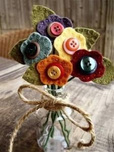 a vase filled with buttons and flowers on top of a wooden table