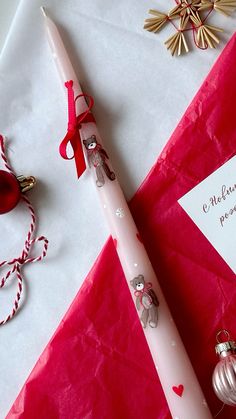 a pink pen sitting on top of a piece of paper next to christmas decorations and a note