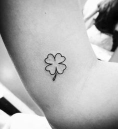 a small four leaf clover tattoo on the left side of the right arm and shoulder