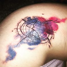 a tattoo on the back of a woman's shoulder that has a globe in it