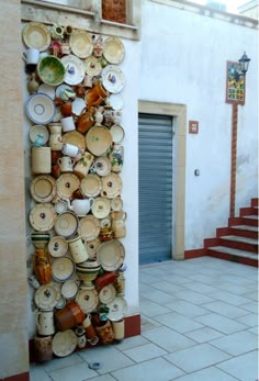 there is a large stack of pots and pans on the side of a building