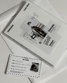 an id card sitting on top of a white envelope with black and white images in it