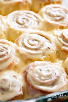 a pan filled with cinnamon rolls covered in icing