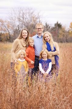 a family posing for a photo in the tall grass