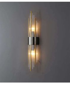 a modern wall light with two lights on the side and one is lit up in gold