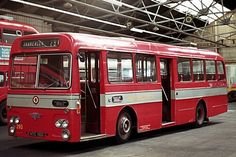 two red buses parked next to each other in a garage with no one on the bus