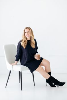 a woman sitting on a chair with a cup of coffee