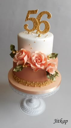 a white and pink cake with gold numbers on top