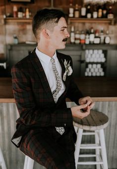 a man sitting at a bar wearing a suit and tie