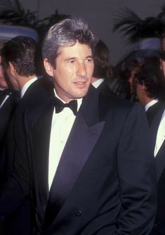 two men in tuxedos are standing next to each other at an event together