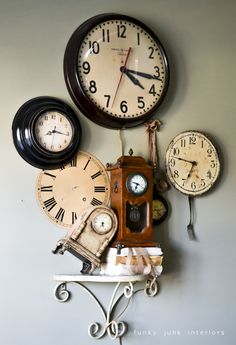 there are three clocks on the wall and one has an old time clock in it