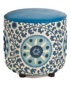 a blue and white ottoman sitting on top of a wooden table