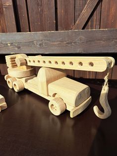 Crane with cargo. Made of solid oak wood. Size: 40 x 11.5 x 16 cm. (maximum shoulder height is 44 cm). Weight: 1.5 kg. The wheels are fully functional. The crane arm is rotatable 360 degrees and moves up - down. The length of the hook can be adjusted using the winch. The toy includes three "beams" 1.5 x 1.5 x 25 cm that fit into the hook. The hook can be exchanged for a demolition hammer and the demolition can begin. Chemically untreated. Demolition Hammer, Le Crochet, Oak Wood, Solid Oak, Czech Republic, Toys