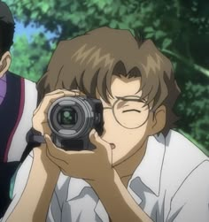 a man holding a camera up to his face with another man looking at him through the lens