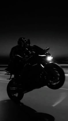 a person riding a motorcycle in the dark