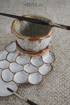 a cup and saucer sitting on top of a table next to two spoons