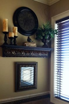 a mirror and some candles on top of a shelf