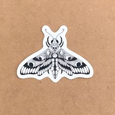 a black and white moth sticker on a brown surface