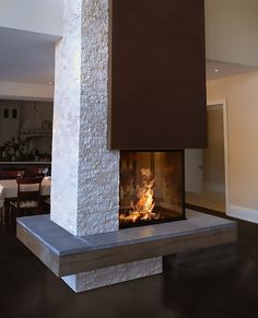 a large fireplace in a living room next to a dining room