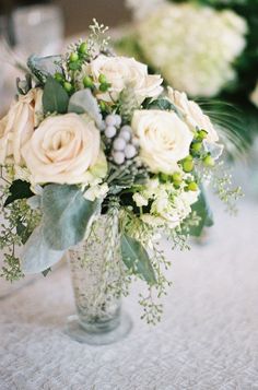 a vase filled with white flowers on top of a table