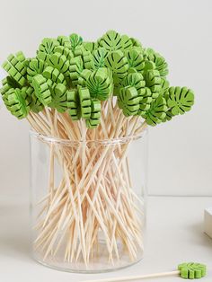 green lollipop sticks in a clear glass vase