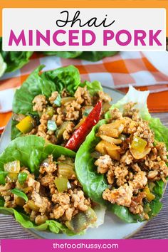 two lettuce wraps filled with minced pork and peppers on a white plate