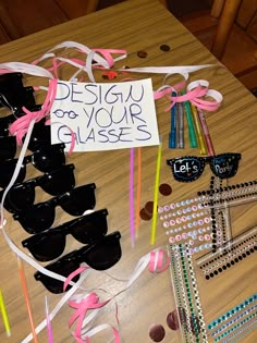 a table topped with lots of glasses and confetti next to a sign that says design for your glasses