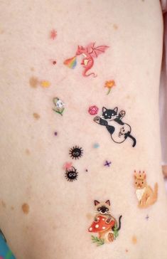 a woman's stomach with many stickers on the side of her body, including cats and kittens