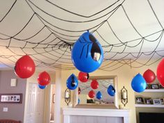 some red and blue balloons are hanging from the ceiling