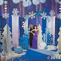 a man and woman standing in front of snow decorations