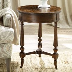 a wooden table sitting on top of a white rug next to a chair and window