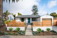 a white house with wooden slats on the front door and side walk leading up to it