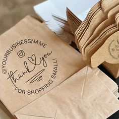 there are many brown bags with writing on them and some envelopes next to each other