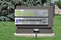 there is a sign for rocky mountain coby in the grass with trees behind it