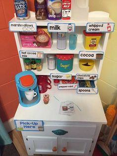 a toy refrigerator with lots of food on it's shelves in a playroom