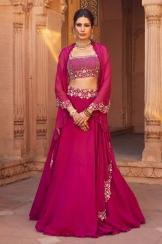 Raspberry lehenga with cutdana embellished waistband. Comes with cape style dupatta and blouse.
Component: 3
Embellished
Neckline: Square
Sleeve Length: Sleeveless
Fabric: Tussar Silk and Organza
Color: Pink
Cape with loop detail and cutwork edge
Scalloped detail on neckline and shoulder straps - Aza Fashions Cape Style Dupatta, Cape Lehenga, Pink Cape, Floral Lehenga, Embellished Neckline, Cutwork Embroidery, Cape Style, Indian Couture, Embroidered Wedding