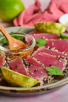 a plate topped with sliced up tuna and garnished with cilantro sauce