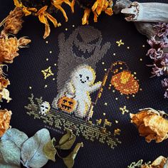 a cross - stitch halloween scene with pumpkins, flowers and a ghost in the background