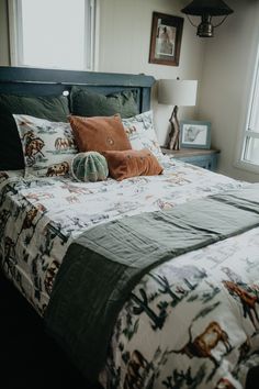 a bed with two pillows on top of it and an animal print comforter in the middle