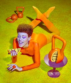 a woman laying on the ground with her body painted orange