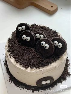 there is a cake with oreo cookies on it and eyes painted on the top