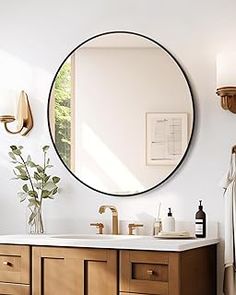 a bathroom with a large round mirror above the sink and wooden cabinetry on the wall