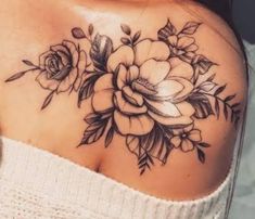 a woman's shoulder with flowers and leaves tattooed on her chest, in black ink