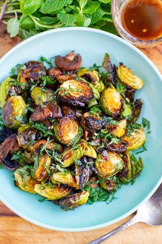 brussel sprouts with bacon and herbs in a blue bowl on a wooden table