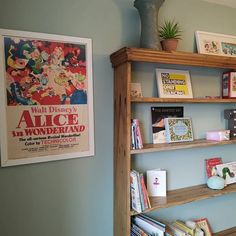 a bookshelf filled with lots of books next to a wall mounted movie poster